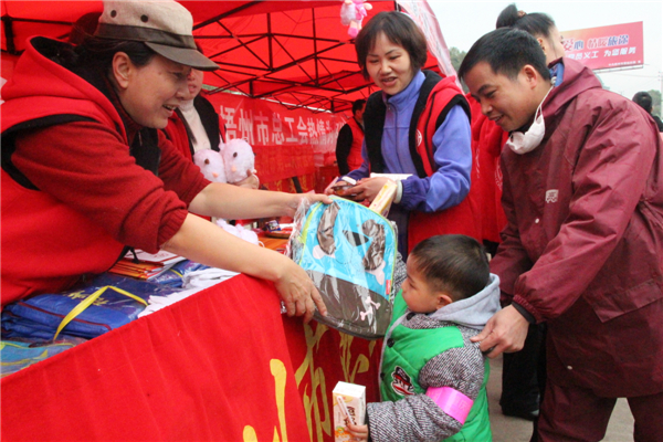 市總工會黨員義工為返鄉(xiāng)務工的小孩送上書包